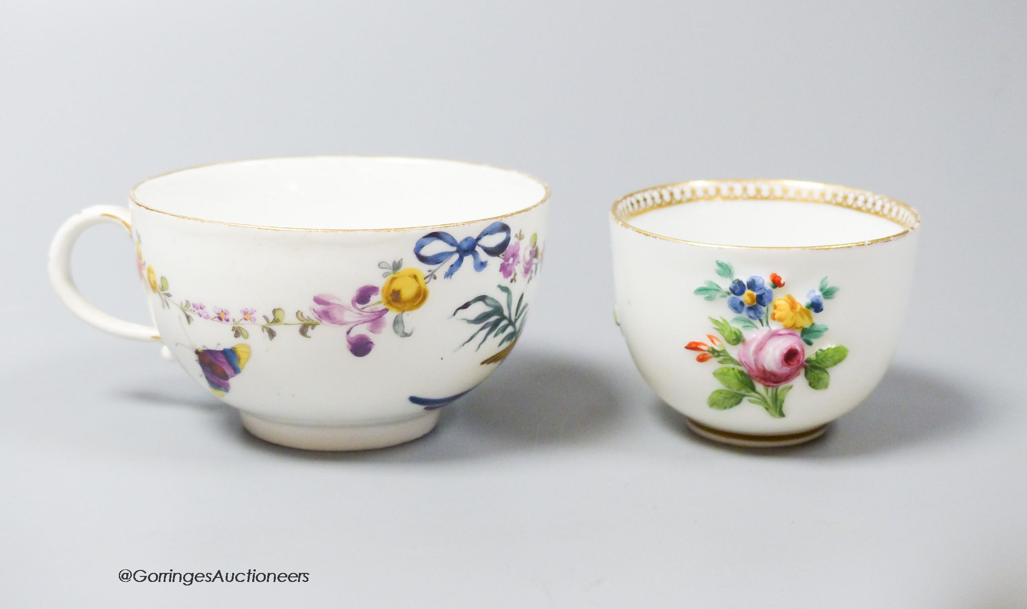 A Meissen bowl, c.1750, moulded and painted with flowers, 6cm diameter and Meissen cup, c.1750 painted with a parrot and flowers (2)